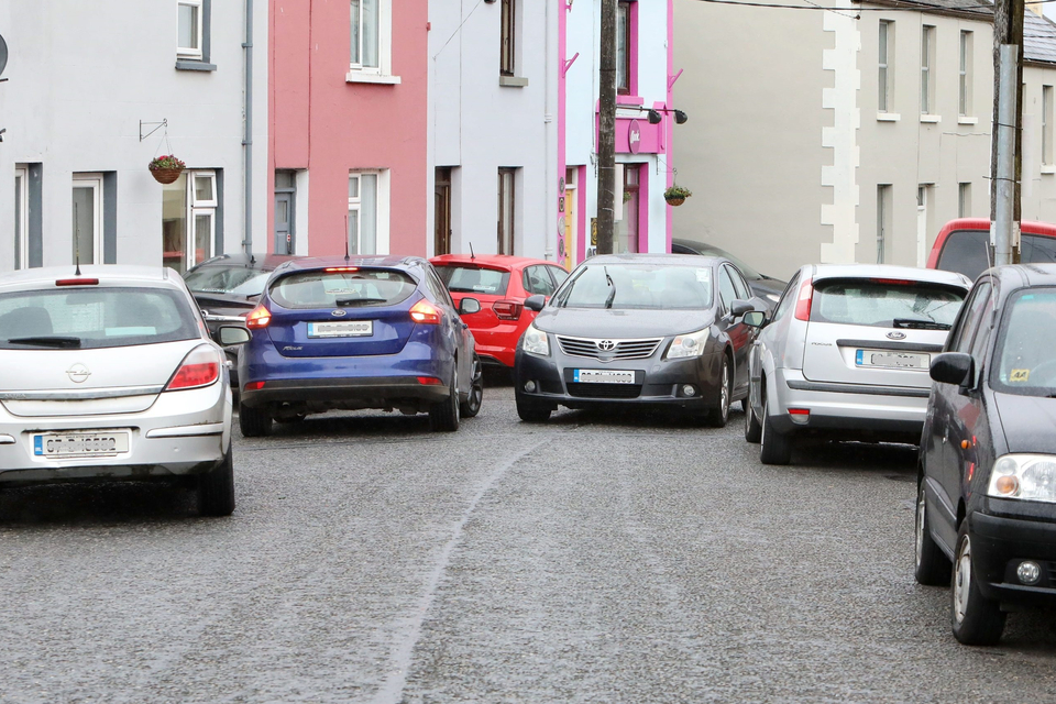 Badly parked cars creating a bottleneck for traffic on a street